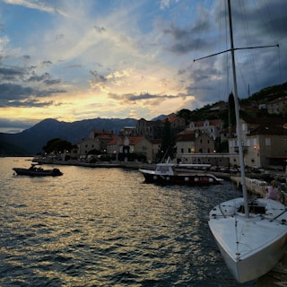 Sunset over a serene Mediterranean seaside village with colorful houses and boats.