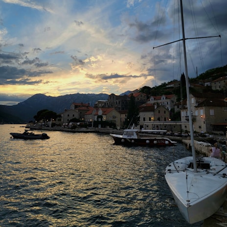 Sunset over a serene Mediterranean seaside village with colorful houses and boats.