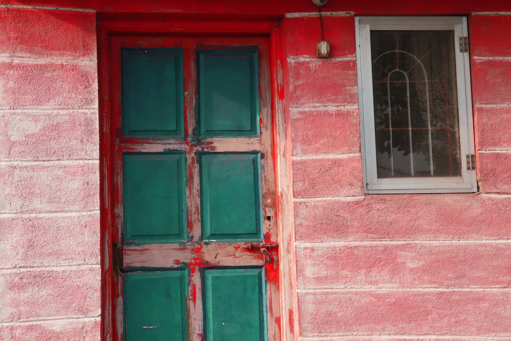 a red building with a green door and window