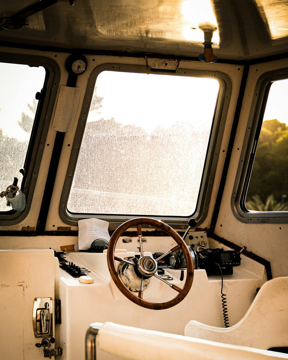 a steering wheel on a boat with three windows