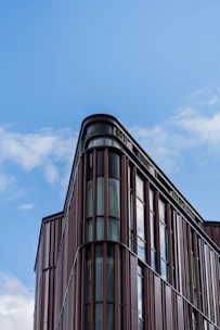 A sleek modern commercial building with geometric patterns and warm brown tones under a clear sky.