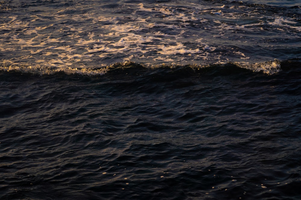 a man riding a surfboard on top of a wave in the ocean