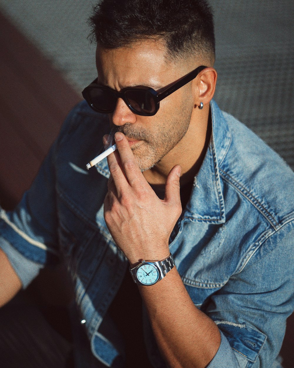 a man in sunglasses smoking a cigarette