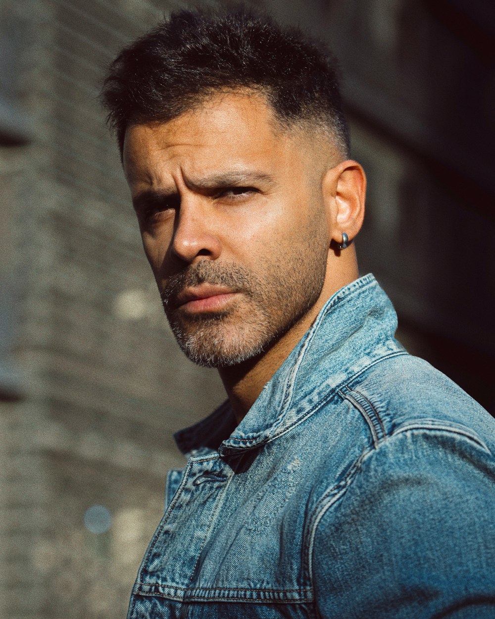 a man in a denim jacket looking at the camera