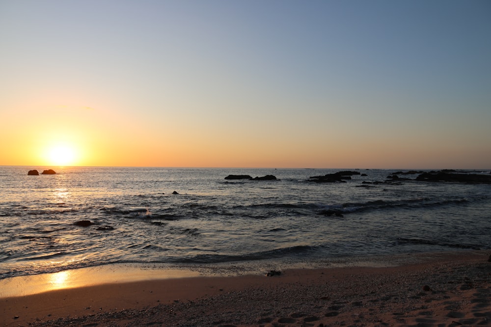 太陽がビーチの海に沈んでいる