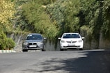 A scenic road with two cars traveling side by side.