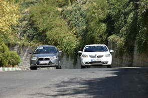 A scenic road with two cars traveling side by side.