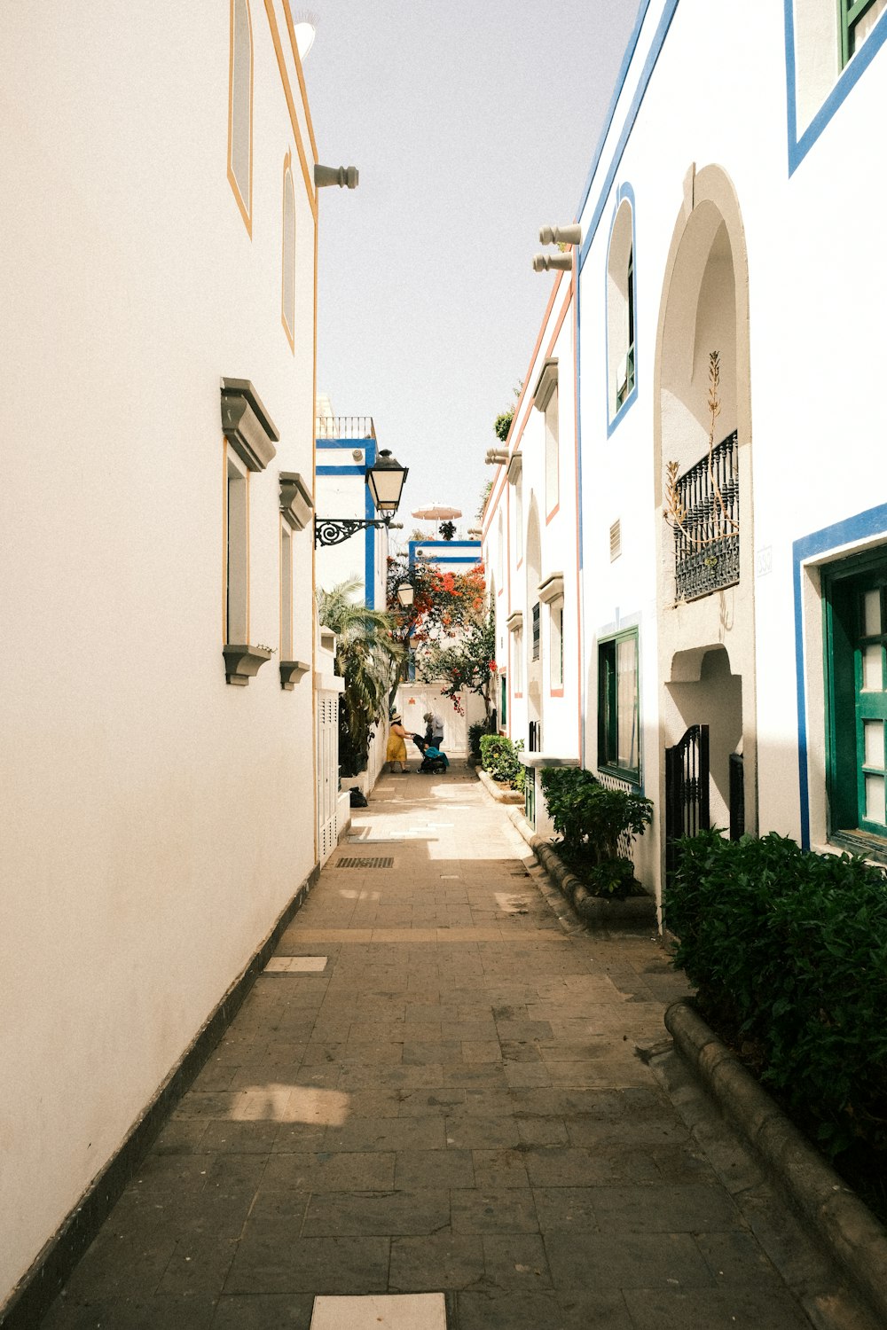 a narrow alley way with white and blue buildings