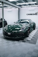 a green sports car parked in a garage