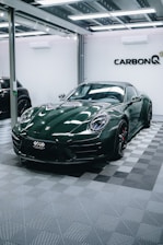 a green sports car parked in a garage