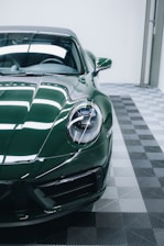 a green sports car parked in a garage