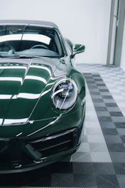 a green sports car parked in a garage
