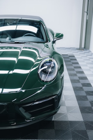 a green sports car parked in a garage