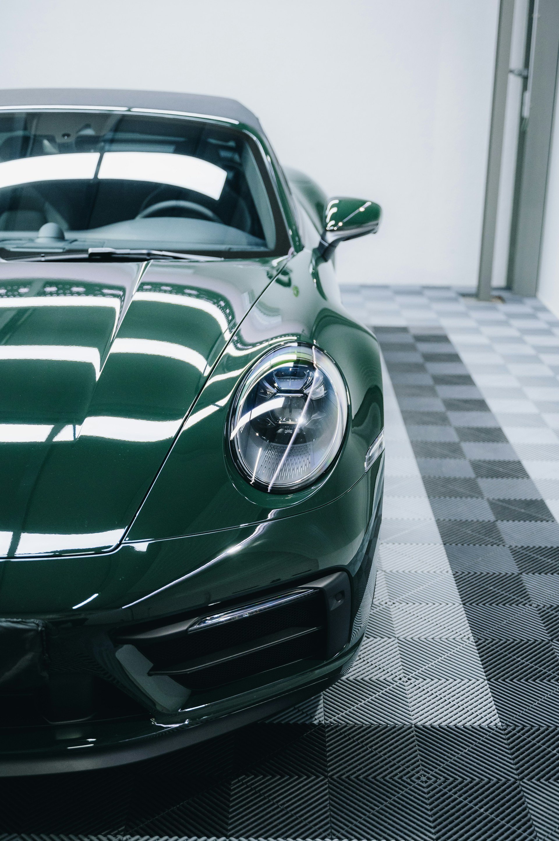 a green sports car parked in a garage