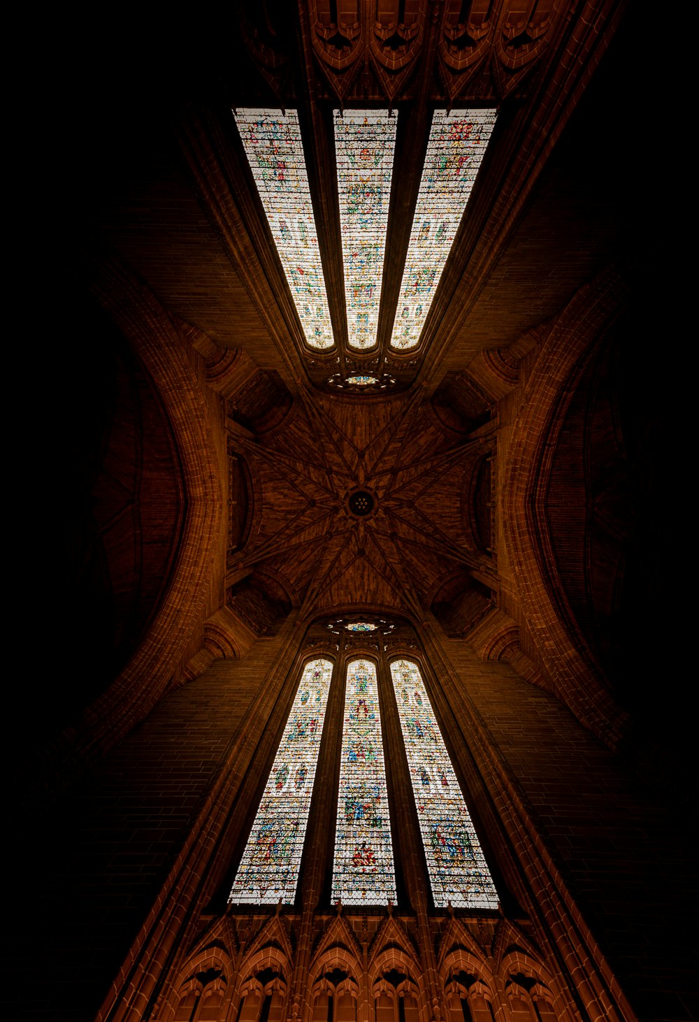 the ceiling of a cathedral with stained glass windows