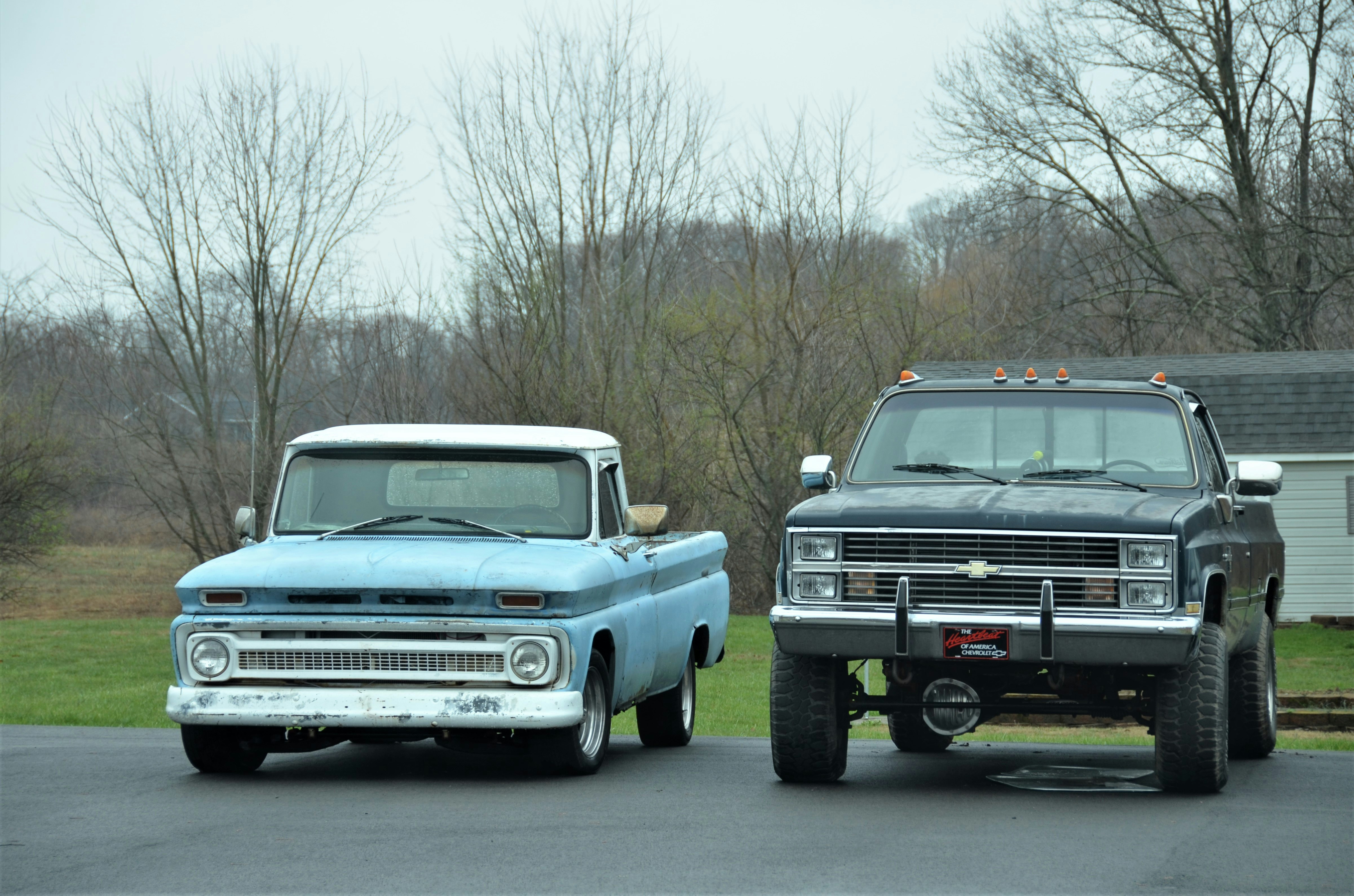 two trucks parked in a parking lot next to each other