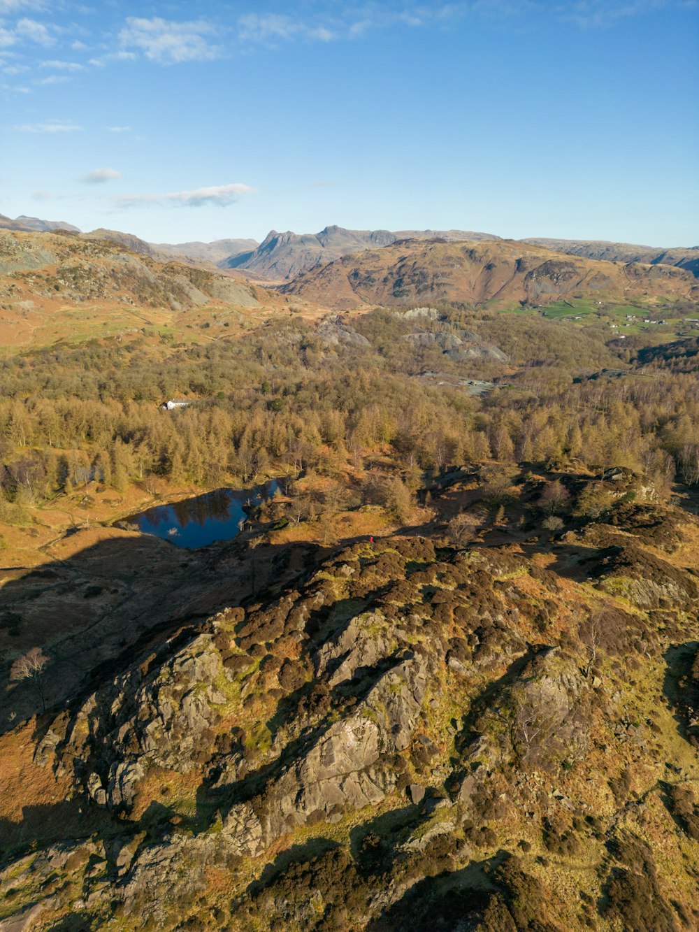 an aerial view of a mountain range with a lake in the foreground