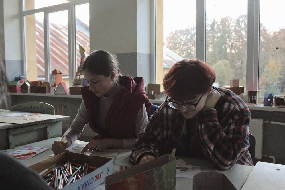 a group of people sitting at a table working on a project