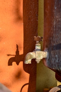 a rusted faucet with a water spigot attached to it