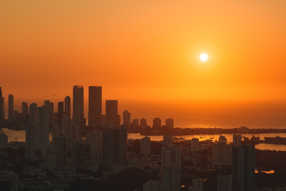 the sun is setting over a large city