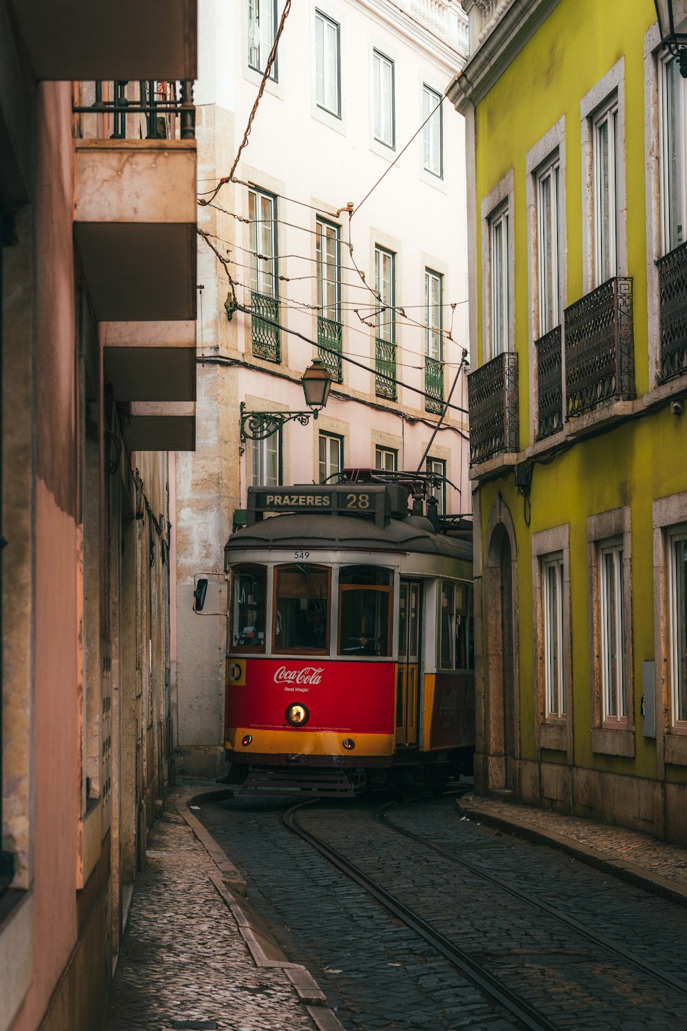 Eine rot-gelbe Straßenbahn fährt eine Straße entlang