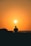 a silhouette of a man fishing at sunset