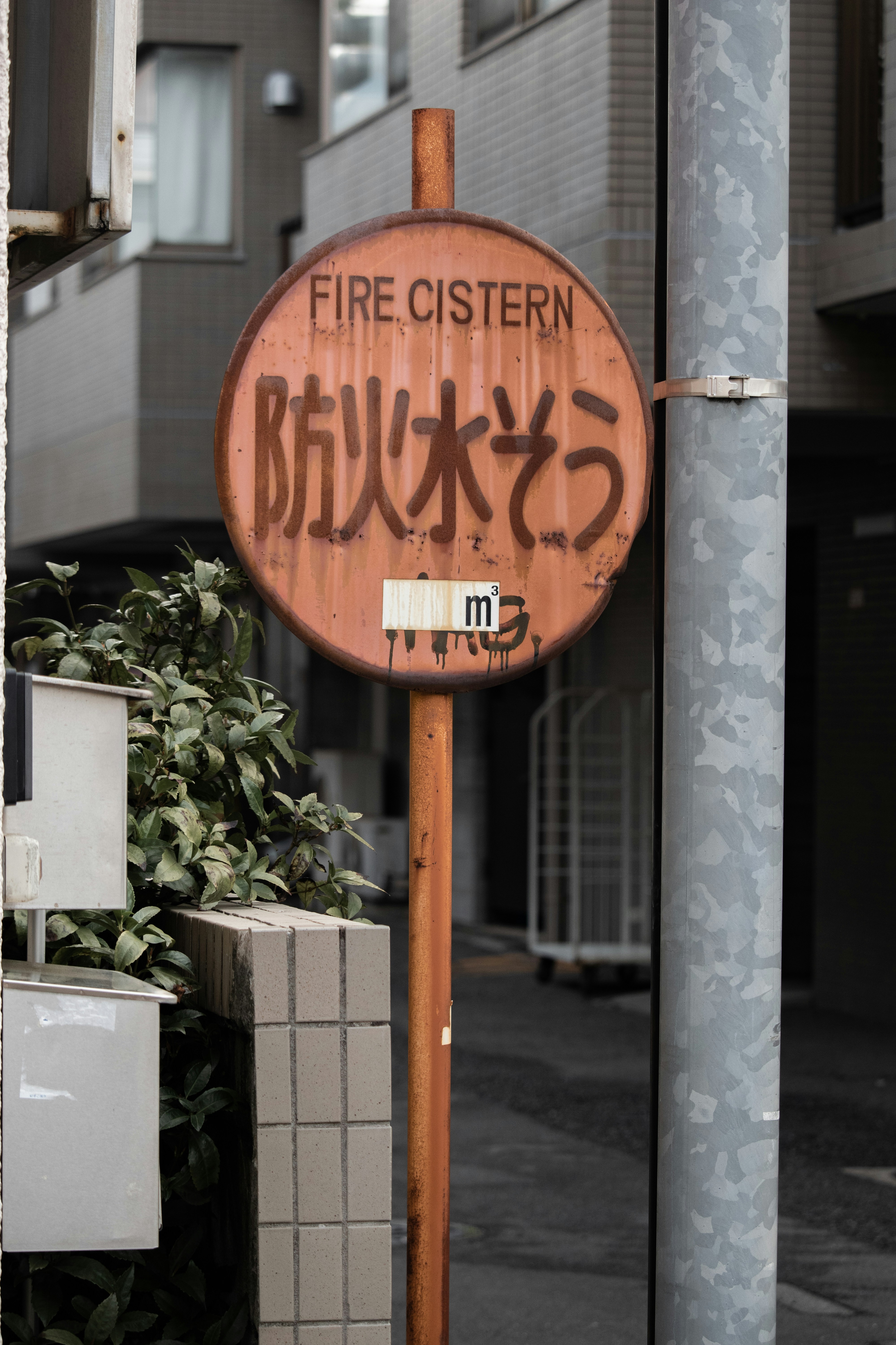 A rusted sign on a pole on a city street photo – Free City Image on ...