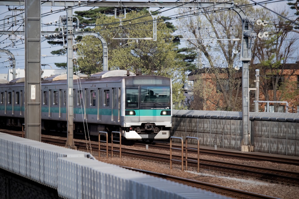 a train traveling down train tracks next to a forest