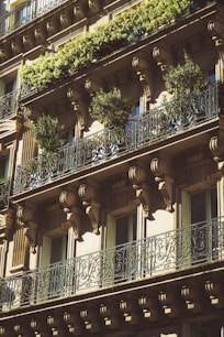 a tall building with balconies and plants on the balconies