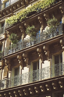 a tall building with balconies and plants on the balconies