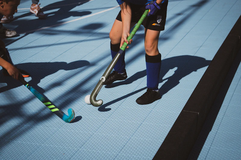 Young men playing field hockey