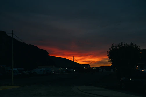 A gritty comic panel featuring a shadowy outlaw silhouetted against a blood-red sunset.