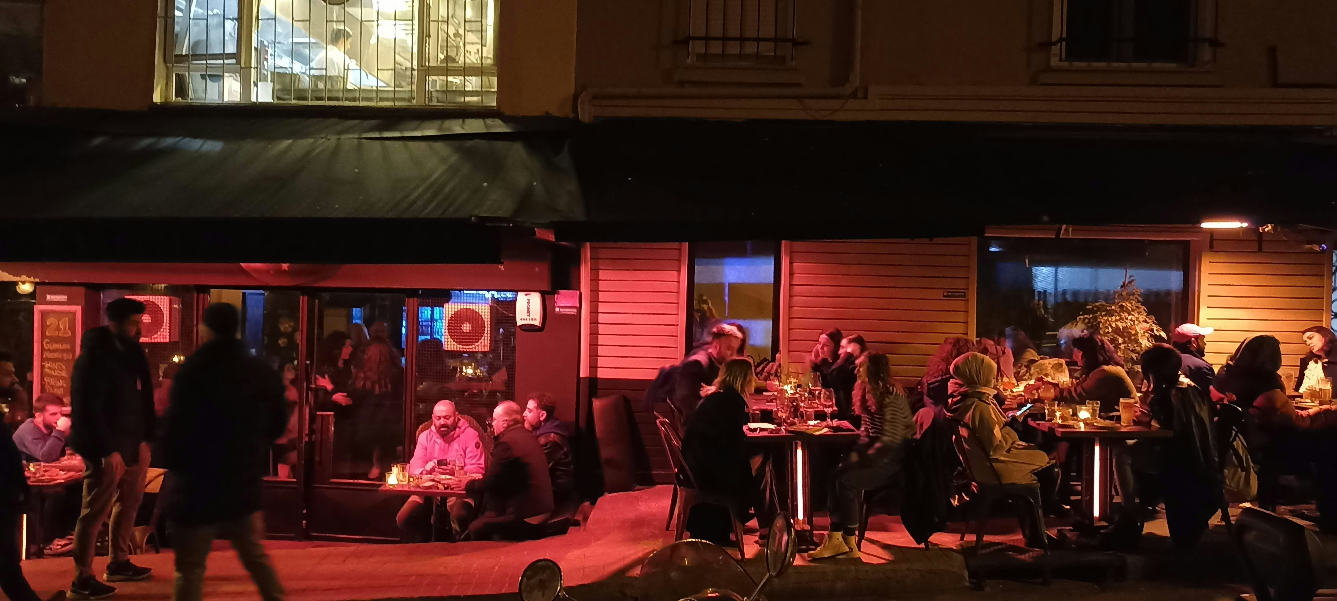 Uptown Chicago nightlife scene showing diverse bars with outdoor patios, neon signs, and people enjoying drinks and conversation - fun bars close to me