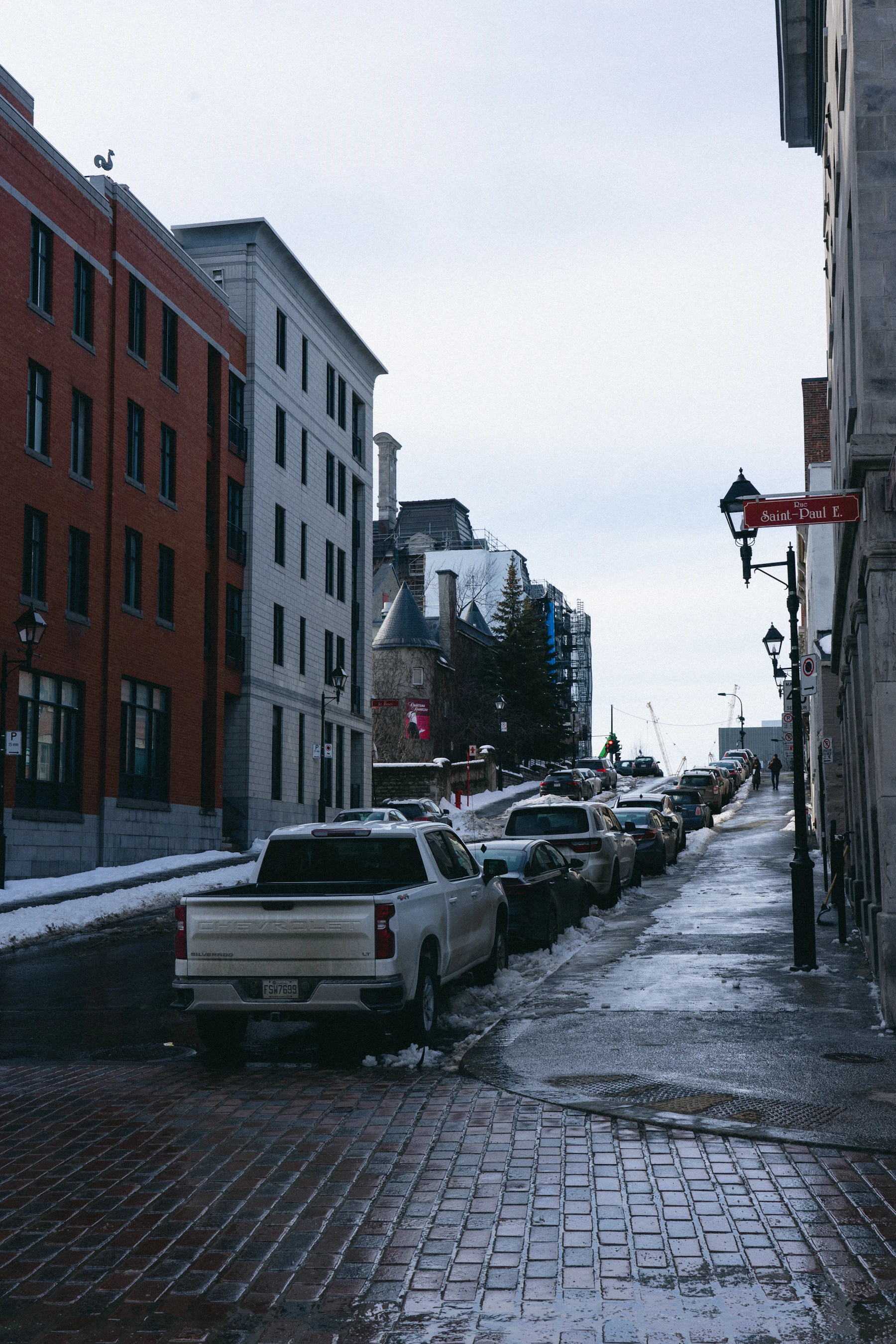 Parked cars line a Canadian city street.