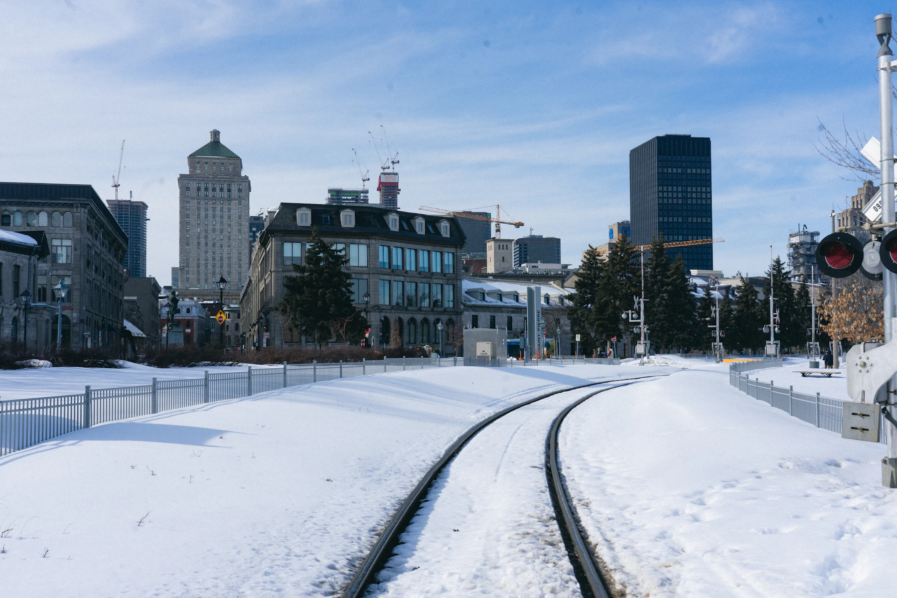 Train tracks run through a snow-covered Canadian city.