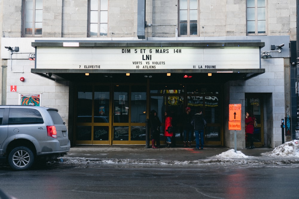 a group of people standing outside of a theater