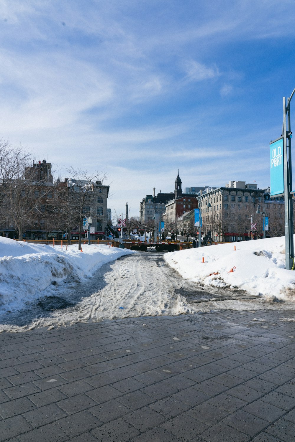 a street with snow on the ground and buildings in the background