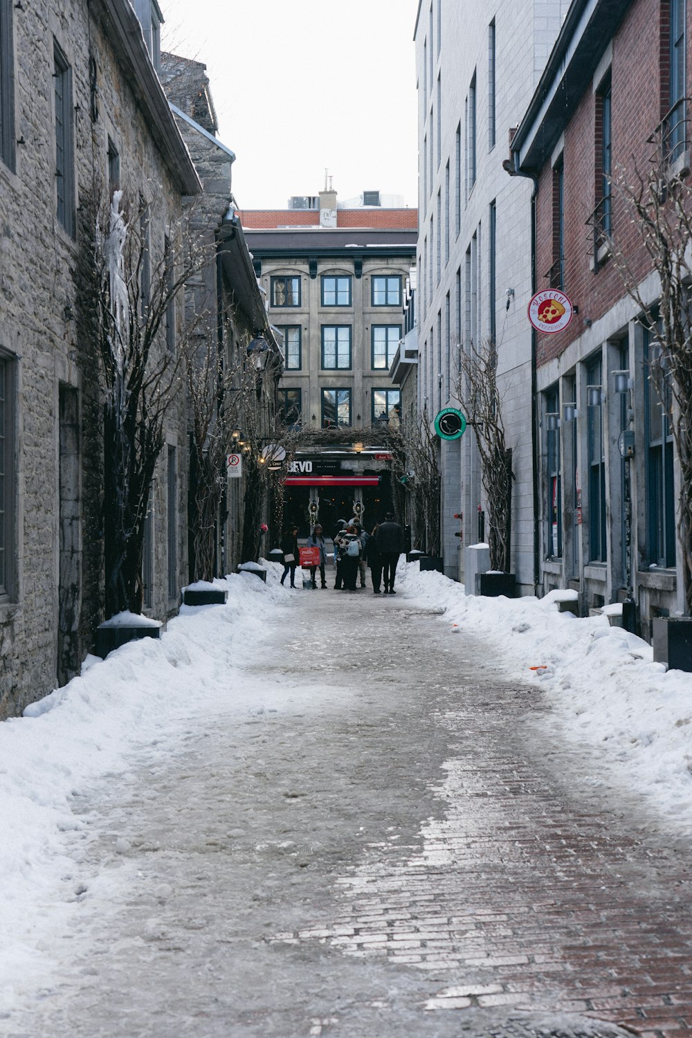 two people walking down a snow covered street