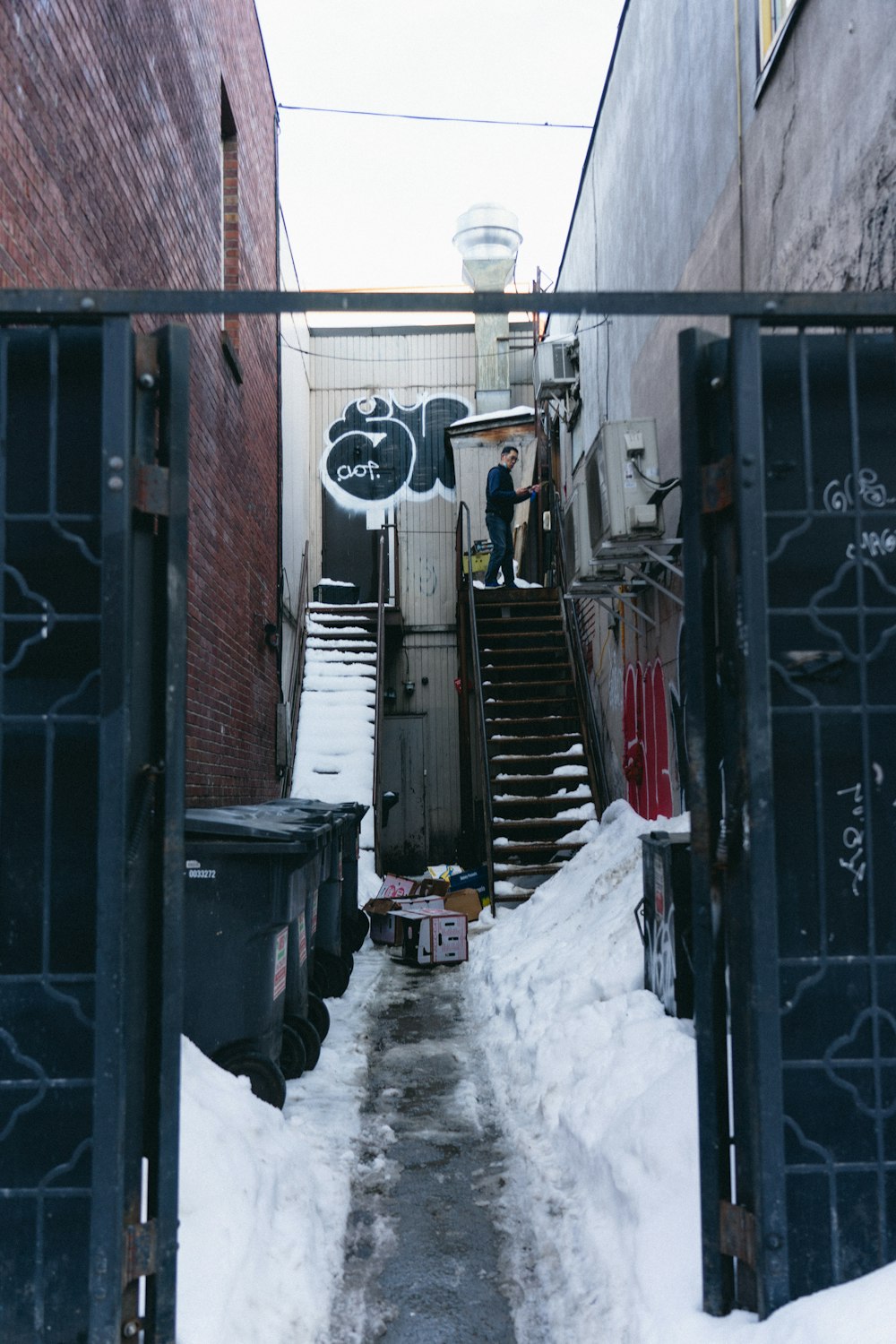 a narrow alleyway with stairs and graffiti on the wall