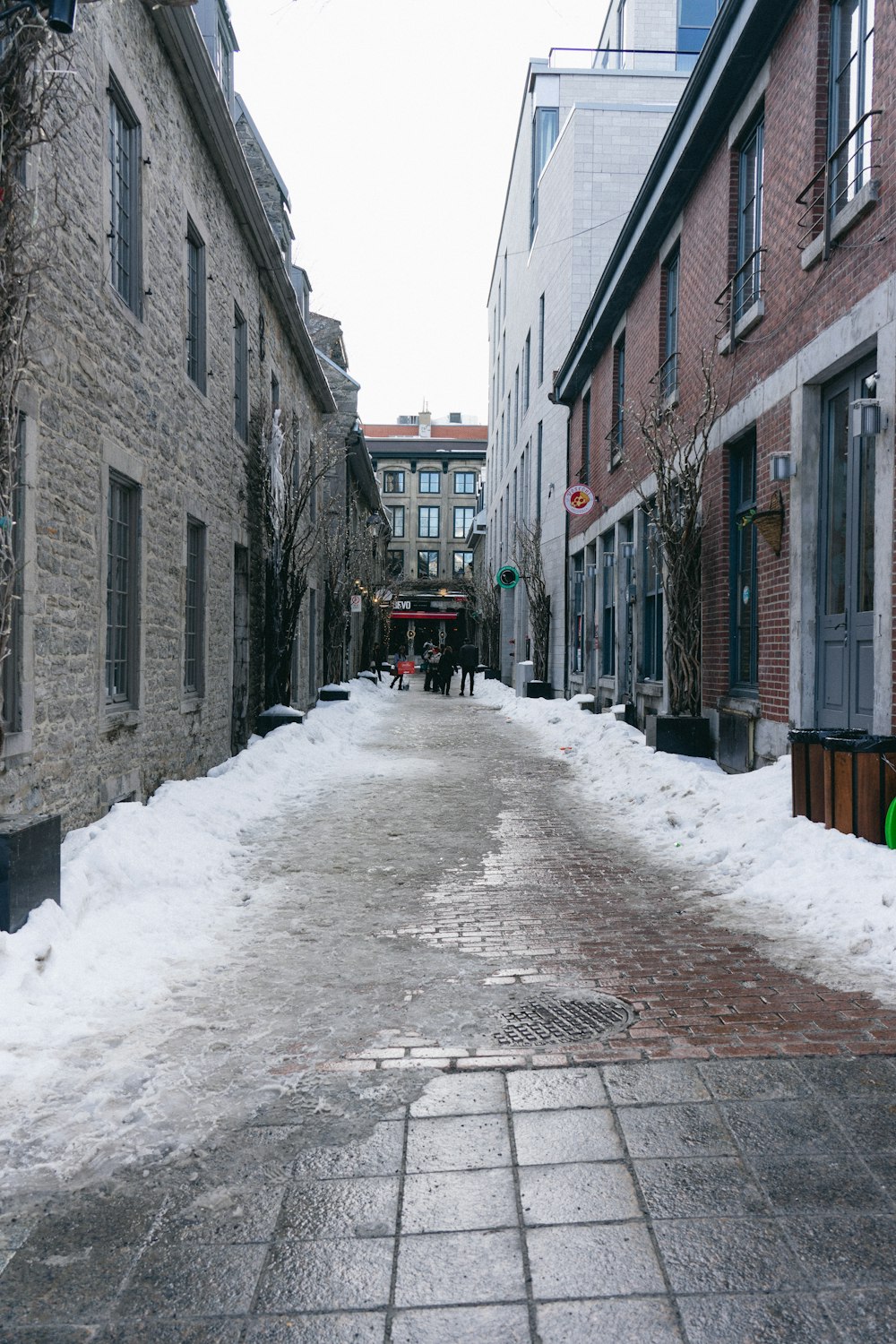 a narrow street with snow on the ground