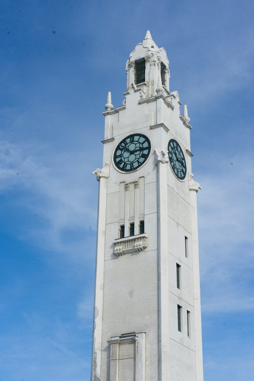 a tall white clock tower with a clock on each of it's sides