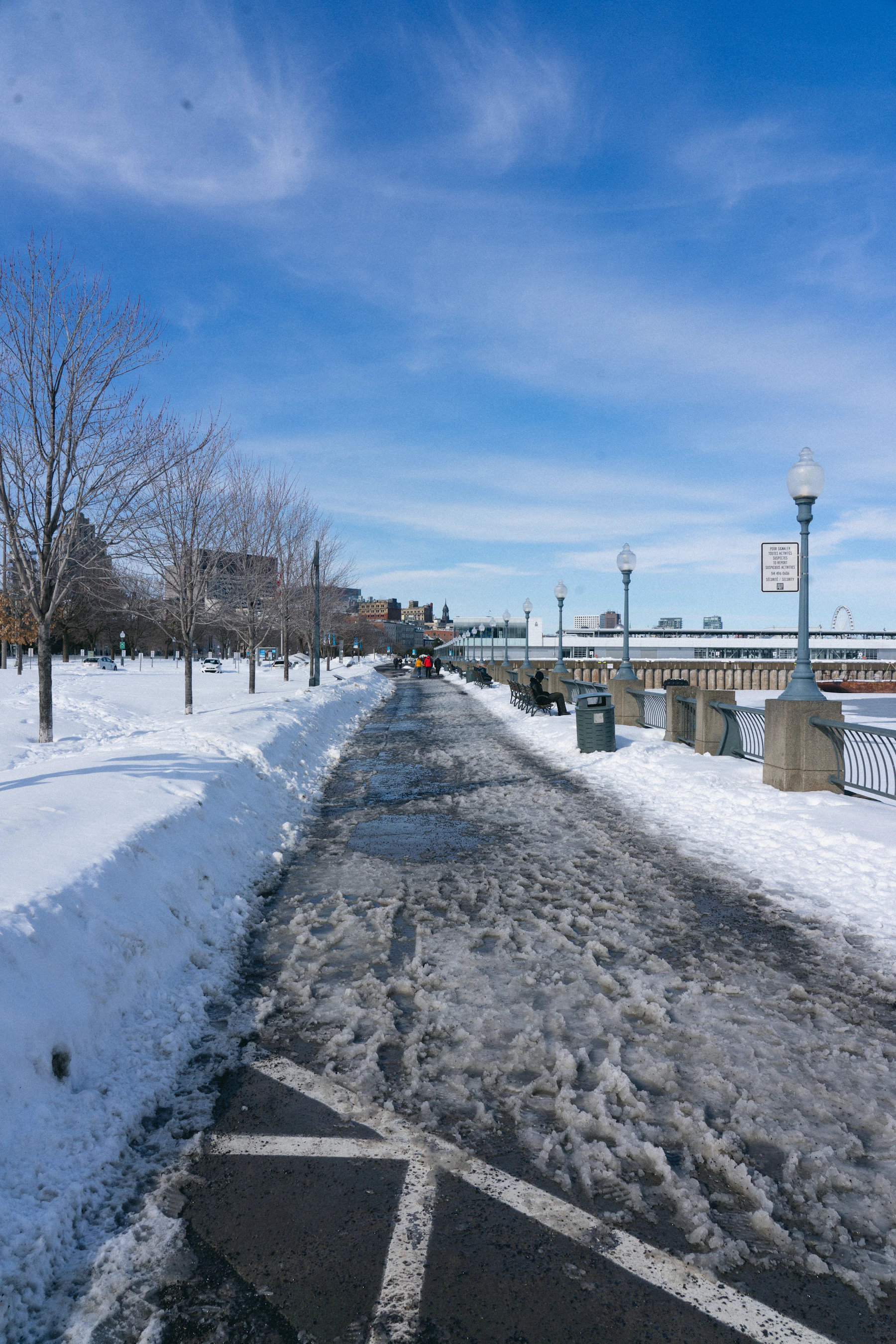 A snow-covered road passes beneath a bridge in Canada.