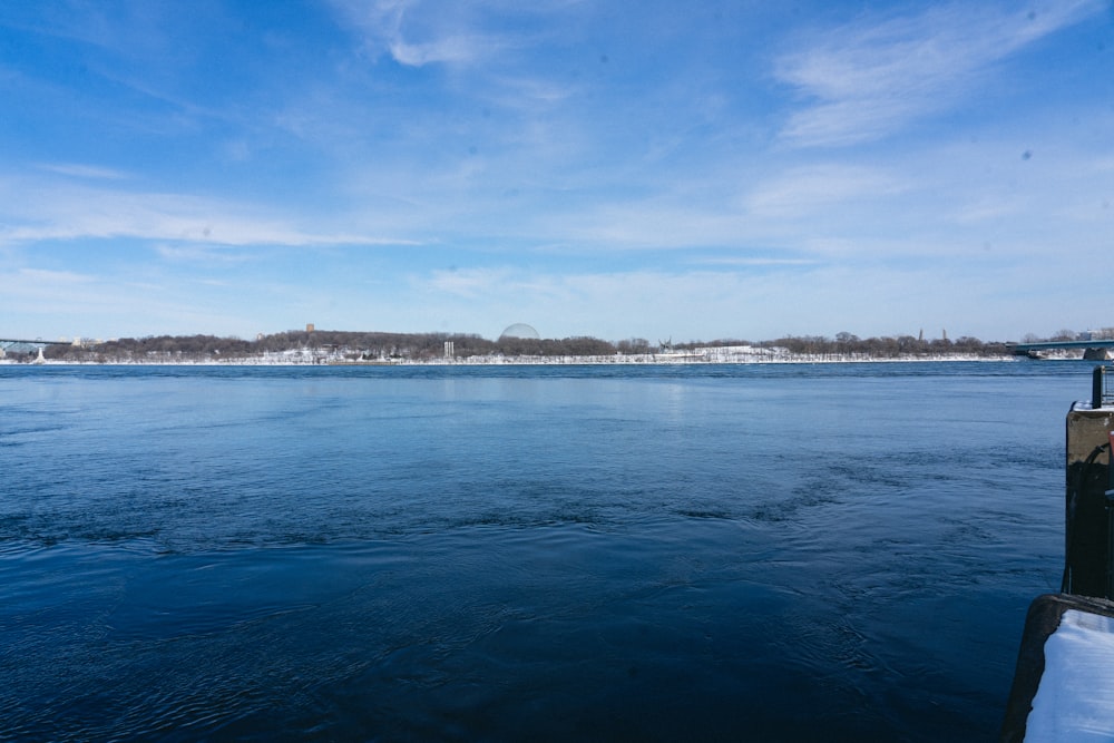 a body of water with snow on the ground