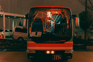 A modern bus parked at a city terminal during sunrise.