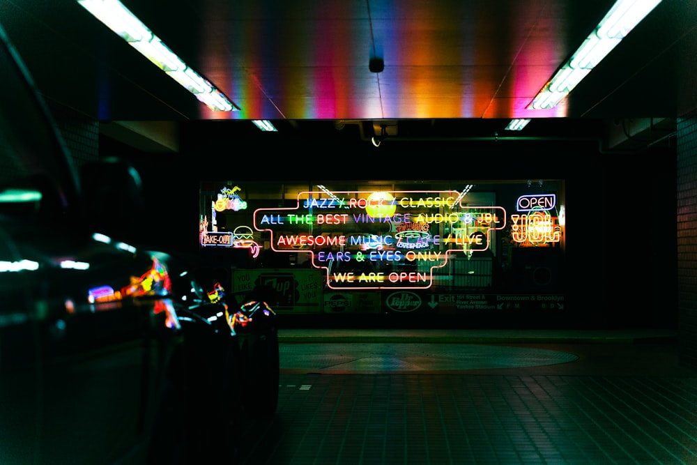 a subway station with neon signs on the wall