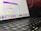 A close-up view of a MacBook Pro showing a section of the screen and keyboard. The screen displays a marketing offer for a subscription service with a limited launch special price. Various app icons are visible on the dock at the bottom of the screen.