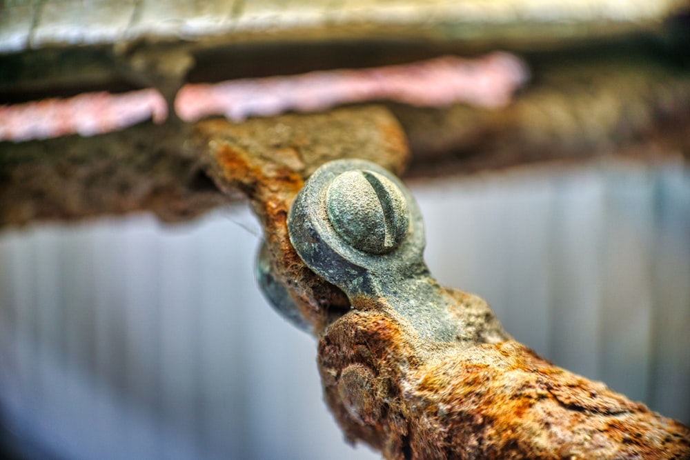 a close up of a rusty pipe with a hat on it