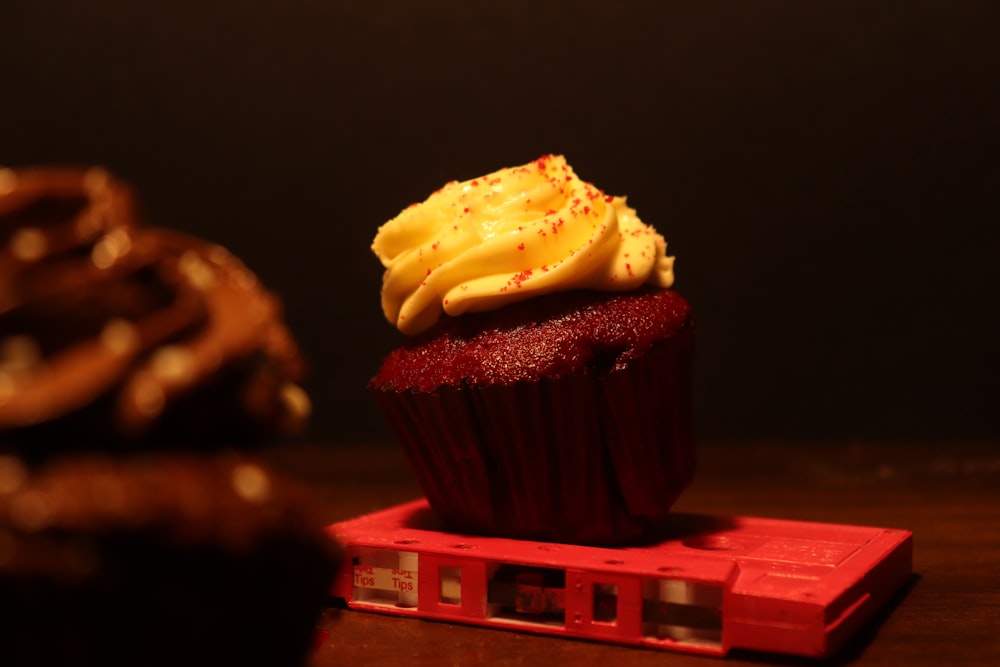 a cupcake sitting on top of a red box
