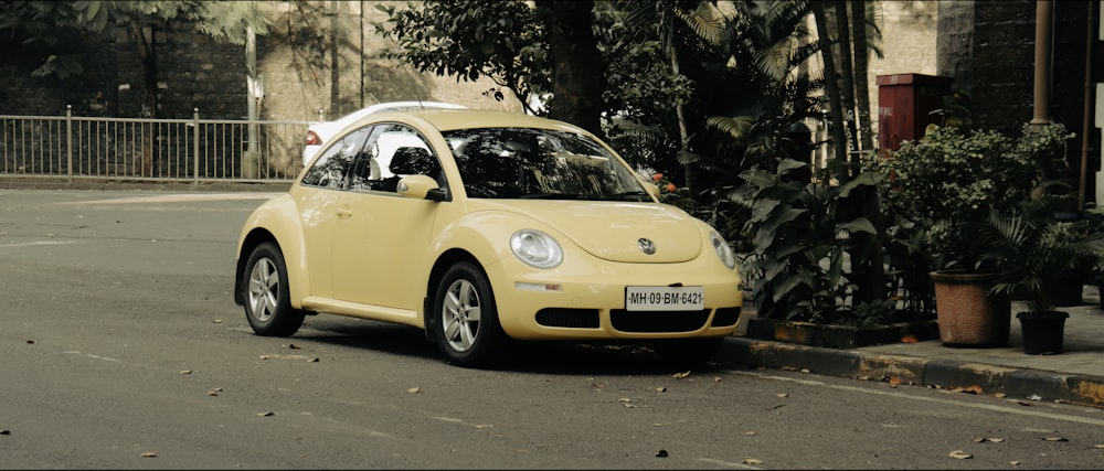 a small yellow car parked on the side of the road