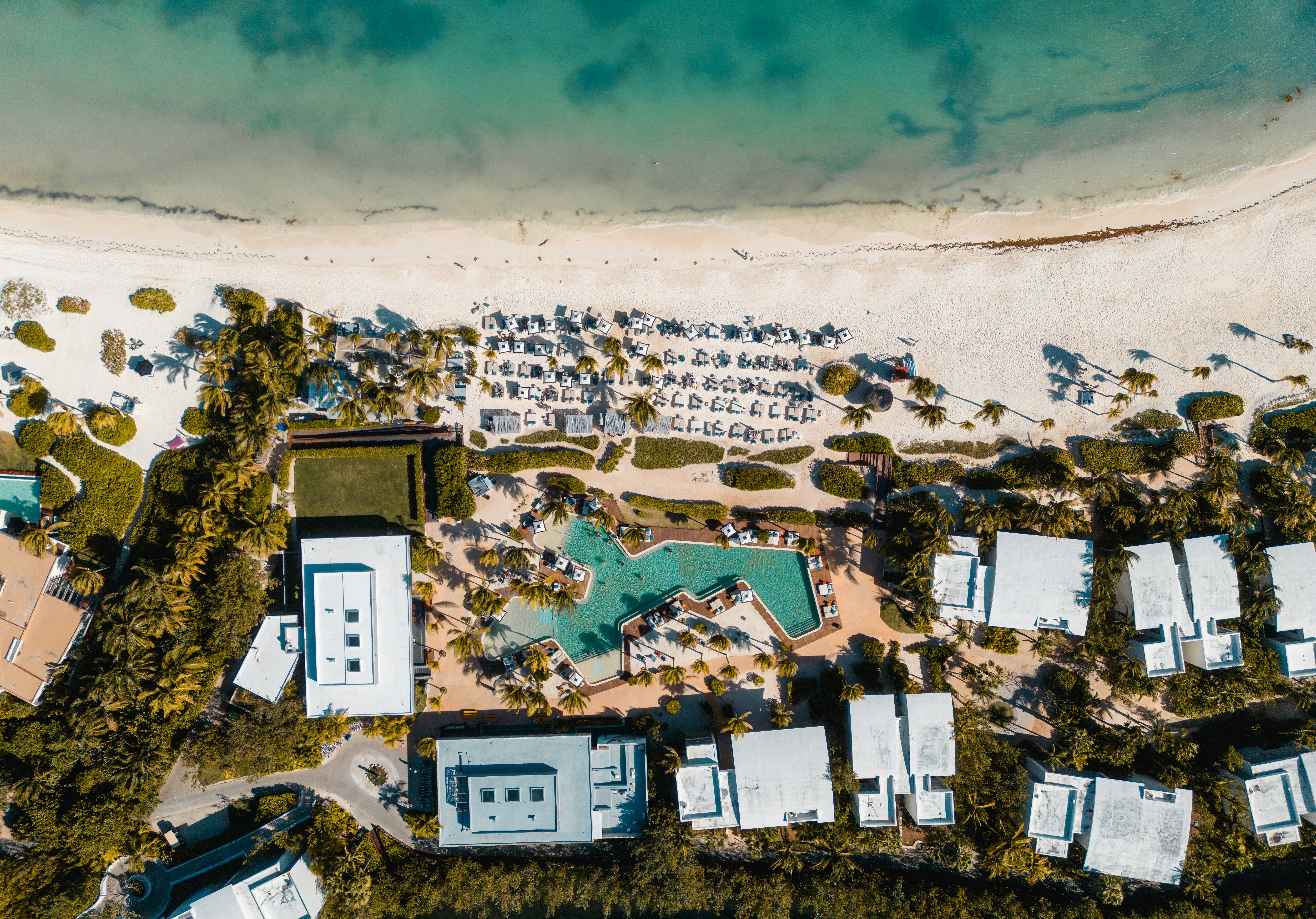 an aerial view of a beach resort with a pool